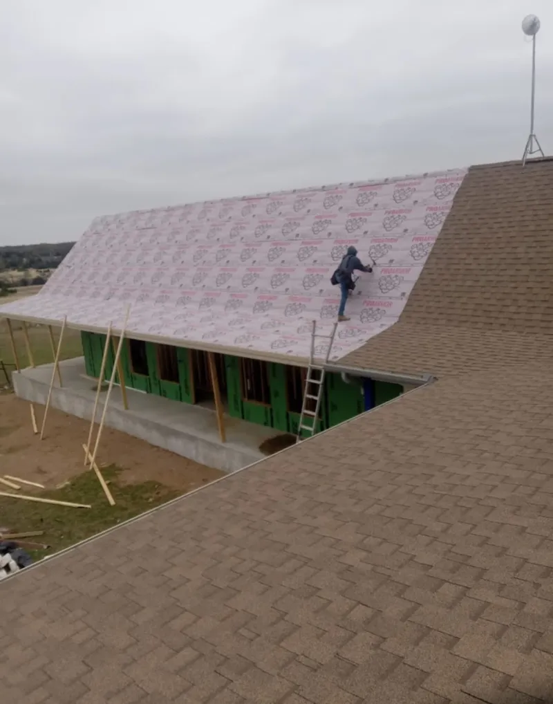 Worker preparing underlayment for a metal roof installation in Panthersville